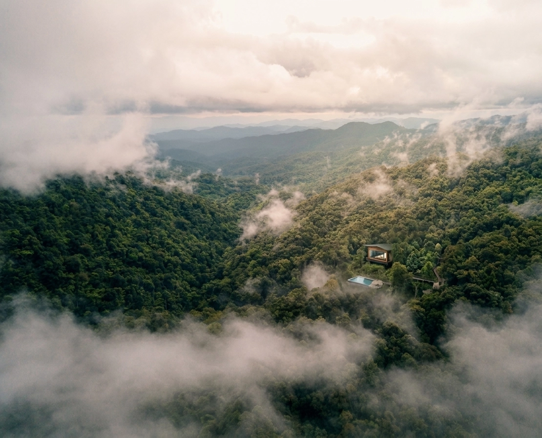 Aerial view of the villa above misty clouds in the jungle